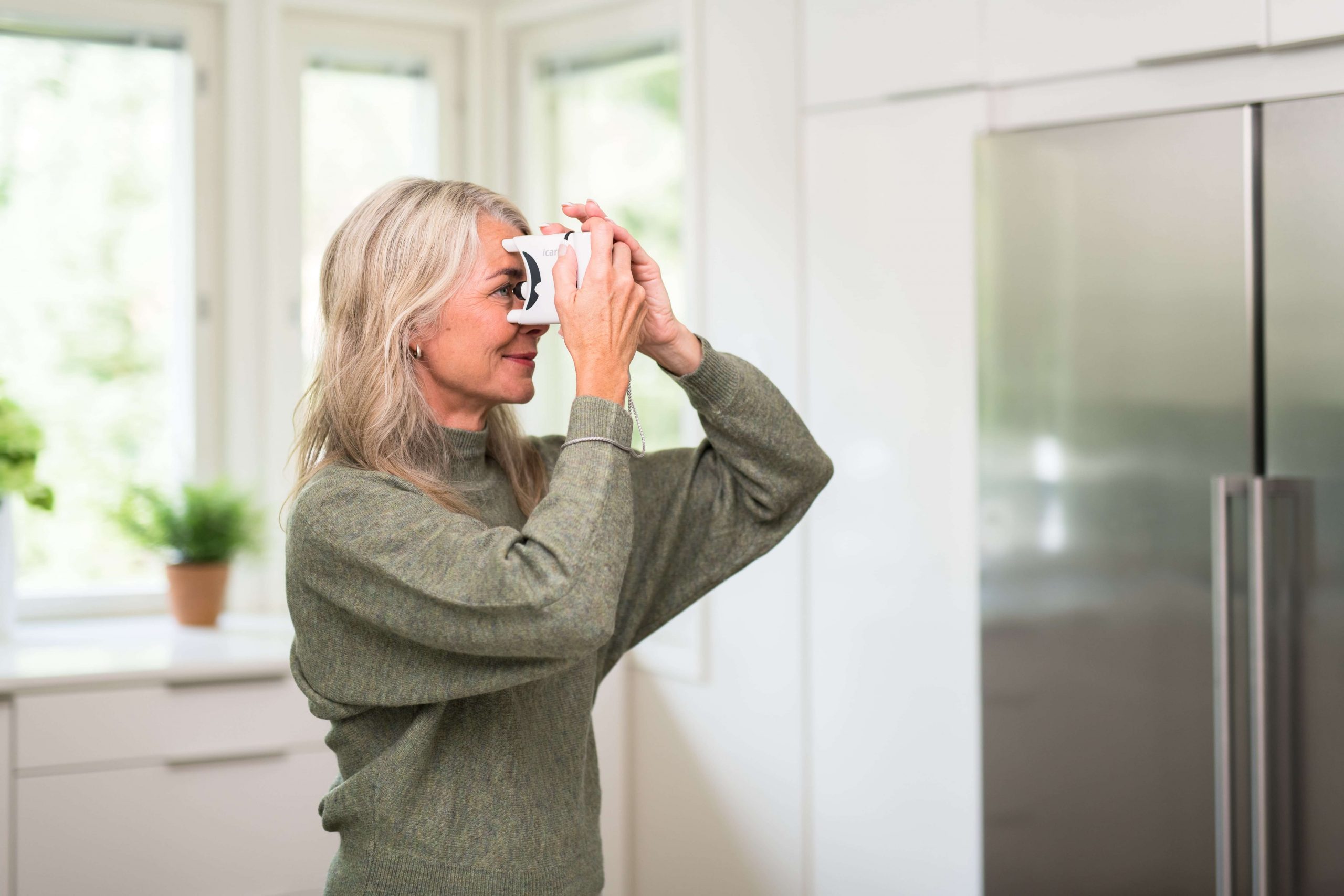 Lady uses a tonometer at home