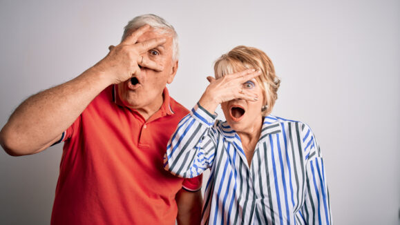 Senior,Beautiful,Couple,Standing,Together,Over,Isolated,White,Background,Peeking