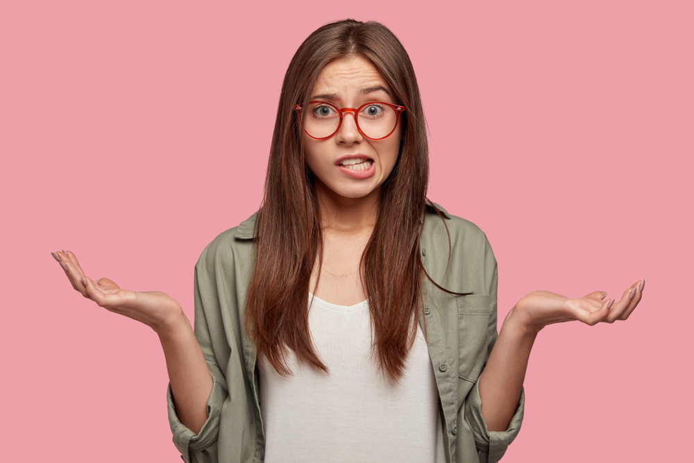 Indifferent,Puzzled,Female,Shruggs,Shoulders,,Purses,Lips,,Has,Clueless,Expression,