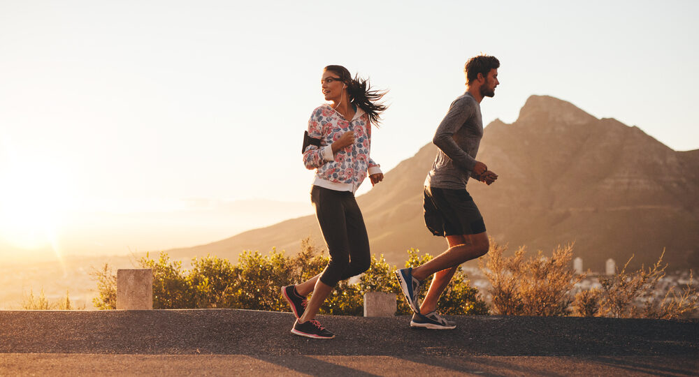 Young,Couple,Jogging,Early,In,Morning,,With,Woman,Looking,Back