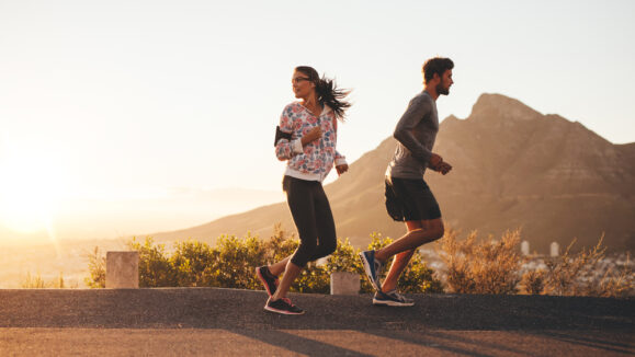Young,Couple,Jogging,Early,In,Morning,,With,Woman,Looking,Back